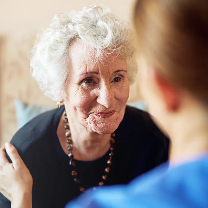 Seniorin lächelt eine Pflegekraft verschmitzt an, symbolisch für die persönliche und vertraute Betreuung durch MonCare Alltagsbegleitung in Monheim